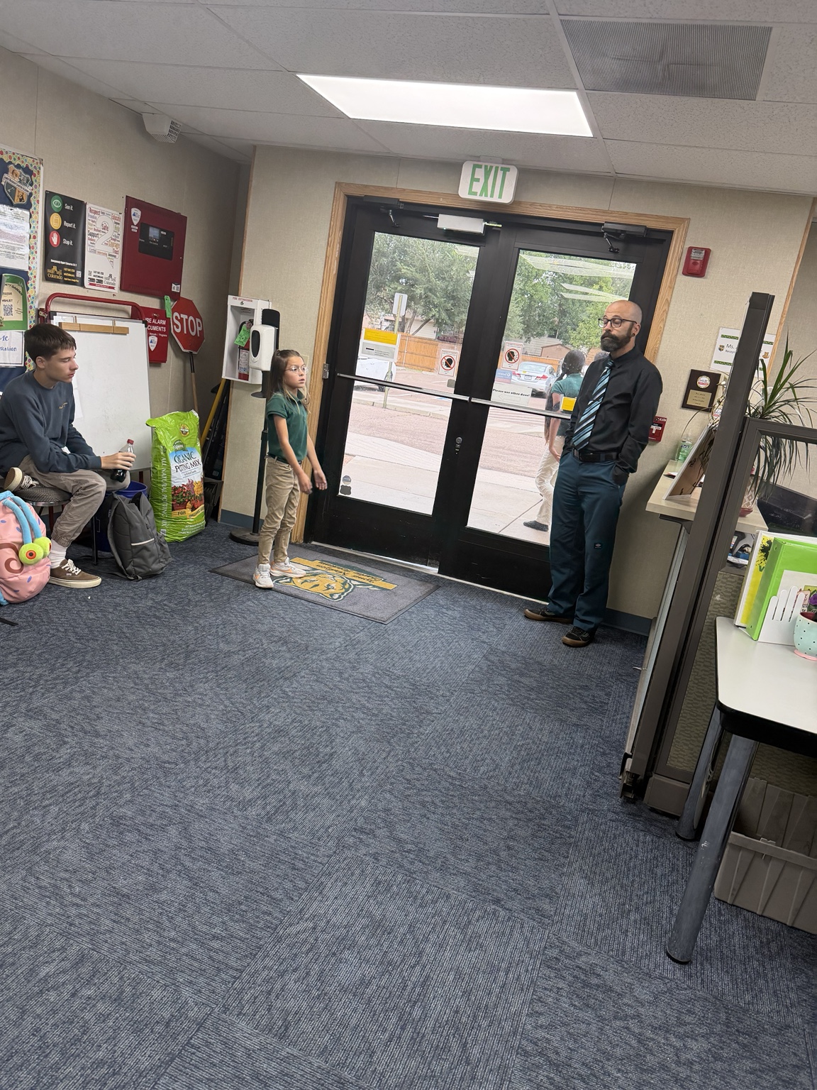 A JMCA staff member greeting students at the school doors